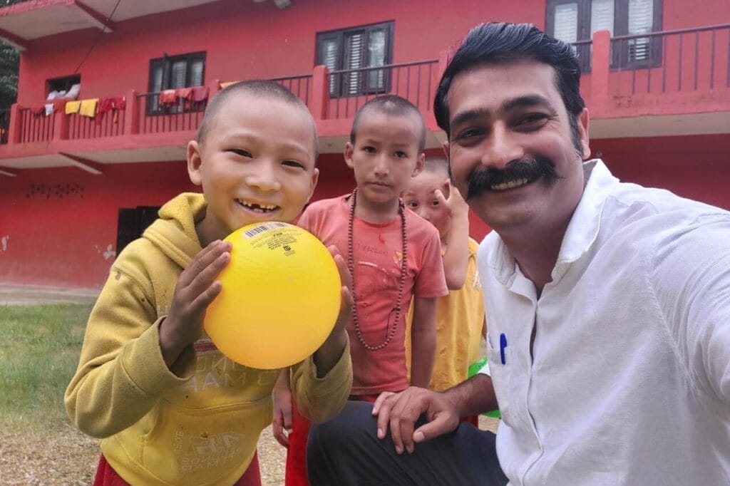 Smiling children and Kapil Raj at an orphanage in Nepal
